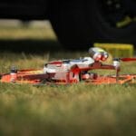 Dron na trawiastej macie startowej gotowy do lotu