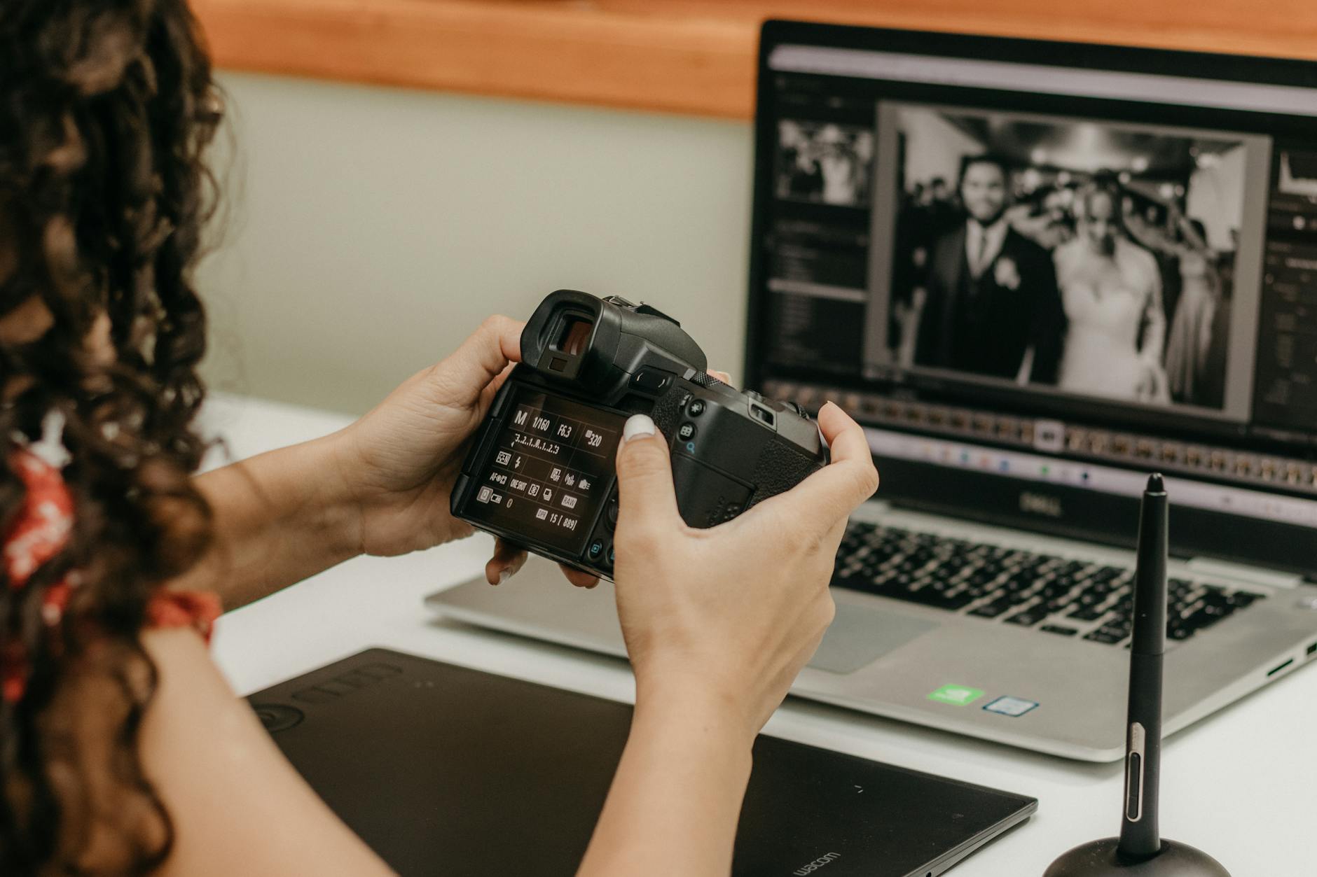 Fotograf przy laptopie edytuje serię zdjęć na ekranie