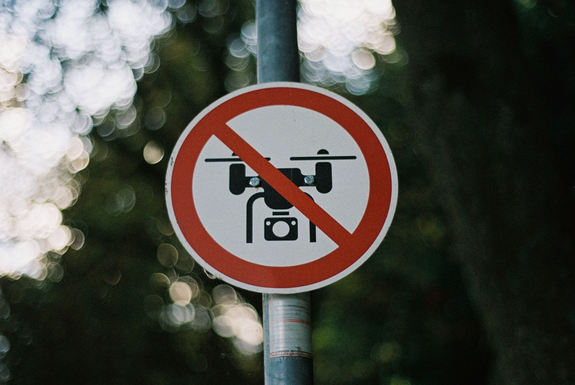 Znak zakazu lotów dronem na słupie w lesie
